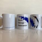 three mugs with SGA logo